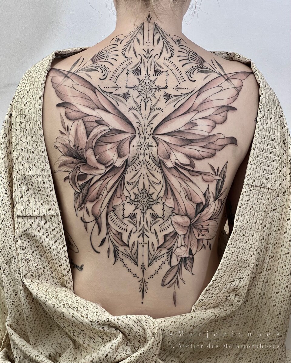 Pièce de dos ornementale en blackwork, papillon et fleurs à l'encre noire