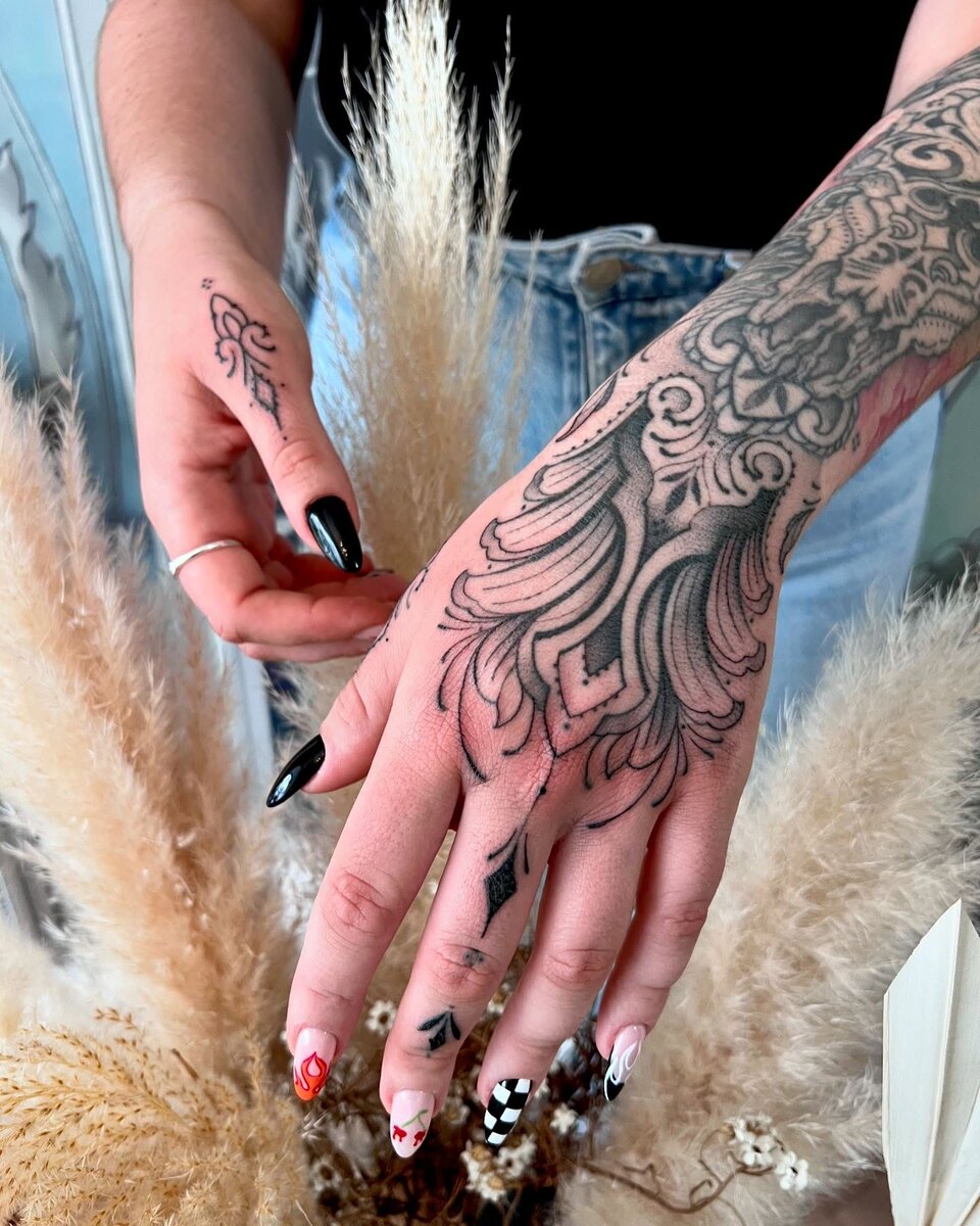 Tatouage ornemental sur la main, motifs de dentelle à l'encre noire